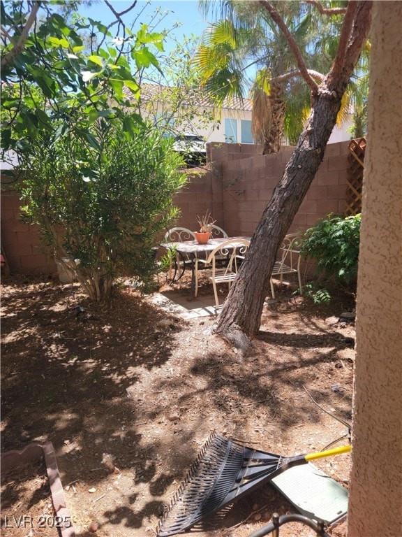 view of yard featuring fence and a patio
