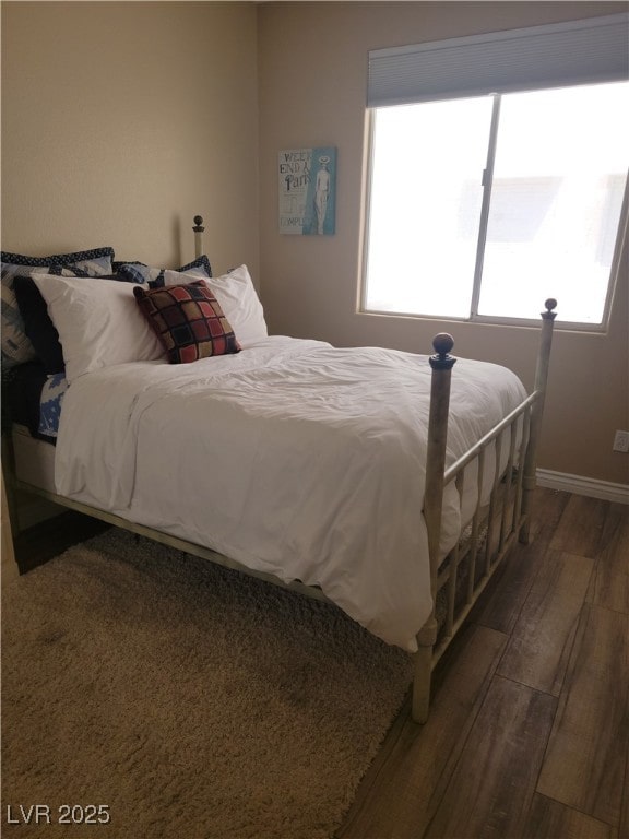 bedroom with wood finished floors and baseboards