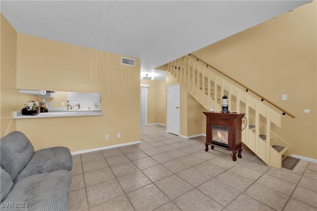 4770 Topaz St Unit 108, Las Vegas, NV 89121 - tiled living area with stairs, baseboards, and a glass covered fireplace