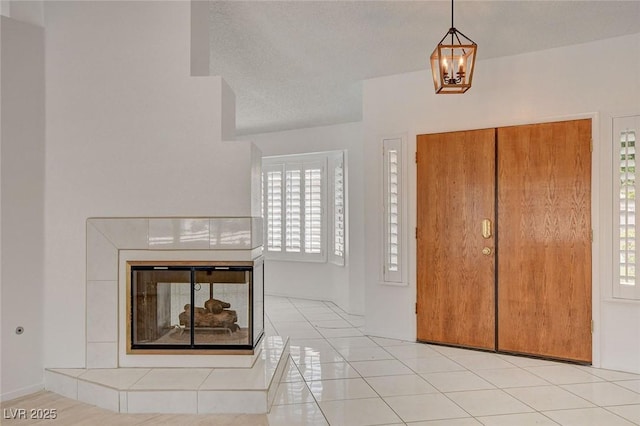 6432 Jean Lee Dr, Las Vegas, NV 89108 - entryway with plenty of natural light, a tiled fireplace, a chandelier, and light tile patterned floors