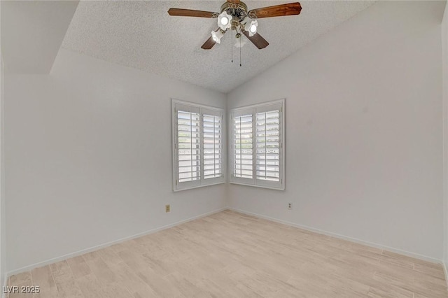 6432 Jean Lee Dr, Las Vegas, NV 89108 - empty room featuring a textured ceiling, vaulted ceiling, light wood-style flooring, a ceiling fan, and baseboards