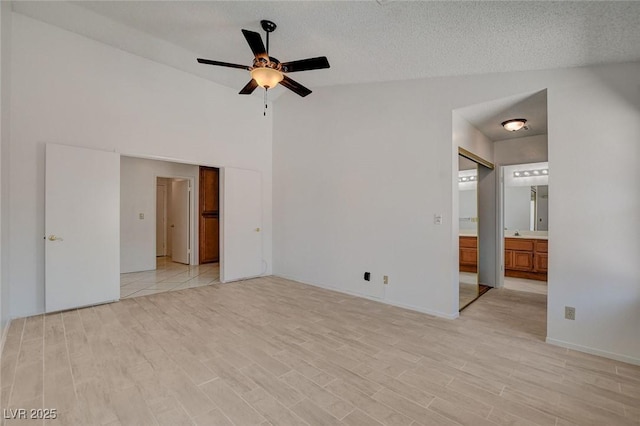 6432 Jean Lee Dr, Las Vegas, NV 89108 - unfurnished bedroom with light wood-style floors, ensuite bath, lofted ceiling, and a ceiling fan