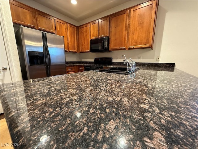 5019 Quiet Falls Ct, Las Vegas, NV 89141 - kitchen with black microwave, gas range, stainless steel fridge, a peninsula, and brown cabinetry