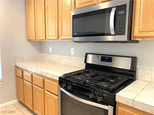 kitchen with stainless steel appliances and light tile patterned flooring