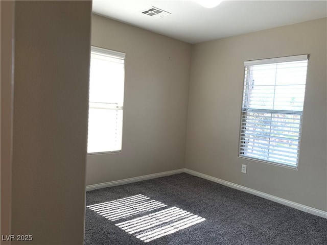carpeted spare room with plenty of natural light and baseboards