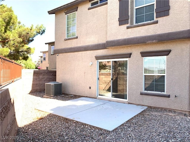 back of property with central AC, a patio, fence, and stucco siding
