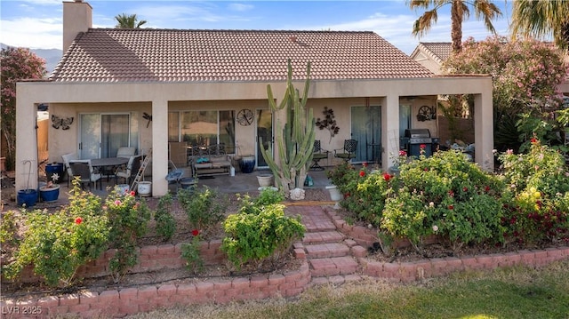 1223 Golf Club Dr, Laughlin, NV 89029 - back of property with a chimney, stucco siding, a patio, and a tile roof