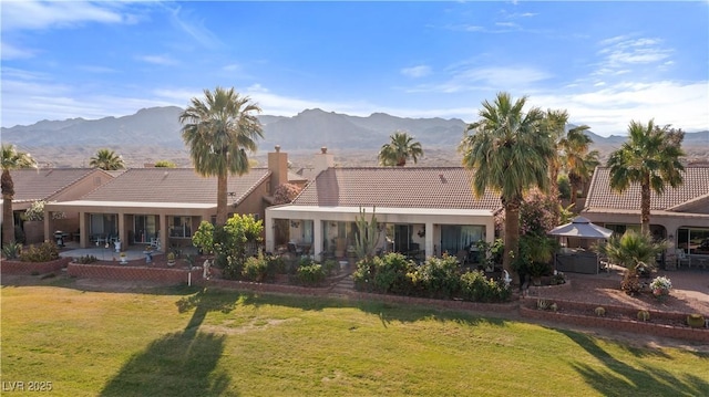 1223 Golf Club Dr, Laughlin, NV 89029 - back of property with a patio area, a lawn, a mountain view, and a tile roof