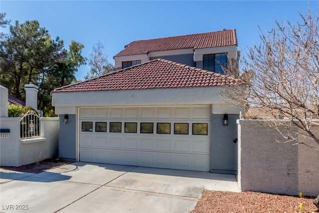 view of front facade with a tile roof, stucco siding, and a garage