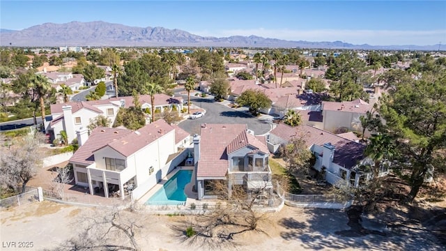 aerial view of residential area with a pool and a mountain backdrop