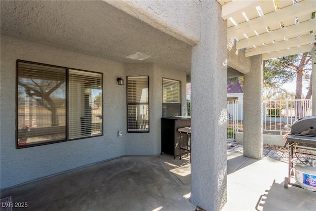 view of patio with fence, grilling area, and a pergola