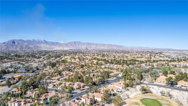 aerial view of property's location featuring a mountainous background, nearby suburban area, and a local golf course
