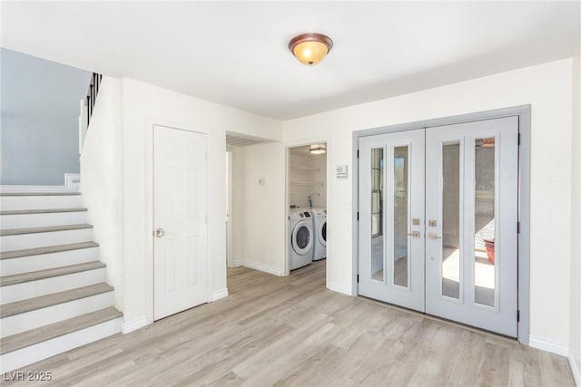 laundry area with washing machine and clothes dryer, french doors, light wood-style flooring, and baseboards