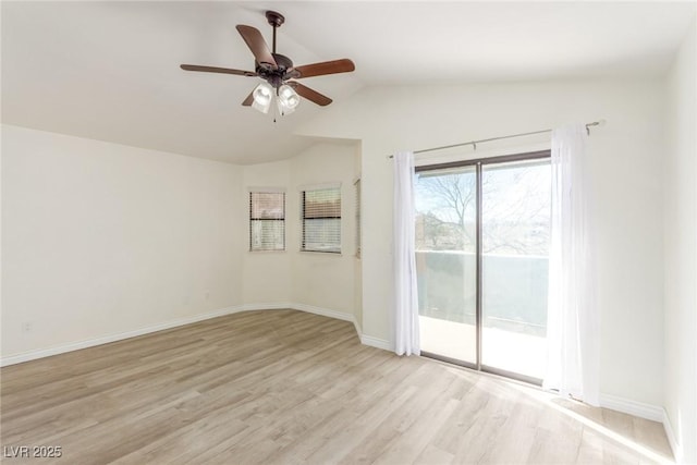 empty room featuring ceiling fan, light wood finished floors, lofted ceiling, and baseboards