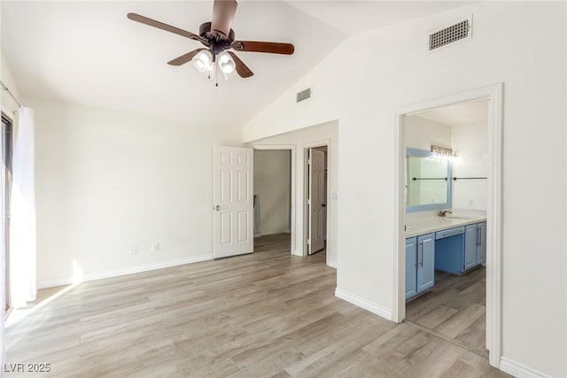 unfurnished living room featuring a sink, a ceiling fan, lofted ceiling, light wood finished floors, and baseboards
