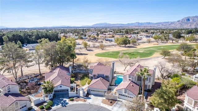aerial view of residential area with a golf course and mountains