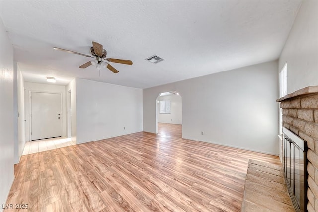 729 Scottsdale St, Henderson, NV 89002 - unfurnished living room featuring a ceiling fan, plenty of natural light, a multi sided fireplace, and light wood-type flooring