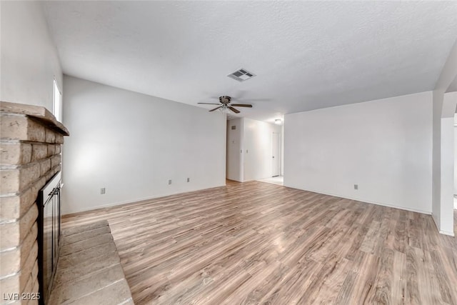 729 Scottsdale St, Henderson, NV 89002 - unfurnished living room with light wood-style floors, a fireplace, and a ceiling fan