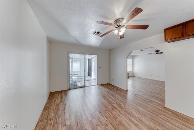 729 Scottsdale St, Henderson, NV 89002 - spare room with a ceiling fan, plenty of natural light, light wood-type flooring, arched walkways, and a textured ceiling