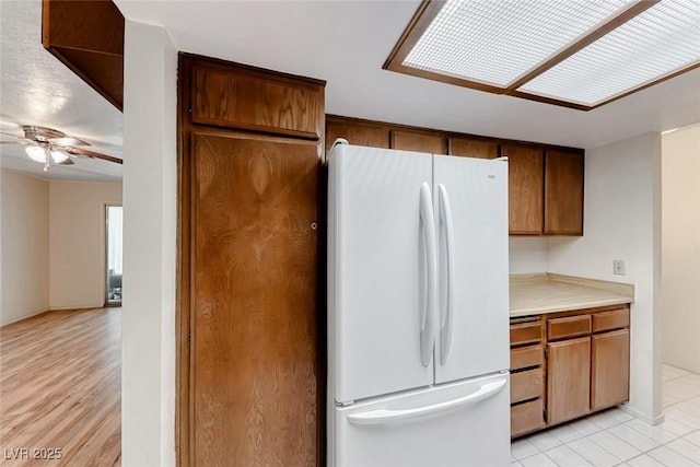 729 Scottsdale St, Henderson, NV 89002 - kitchen featuring freestanding refrigerator, ceiling fan, light countertops, and brown cabinetry