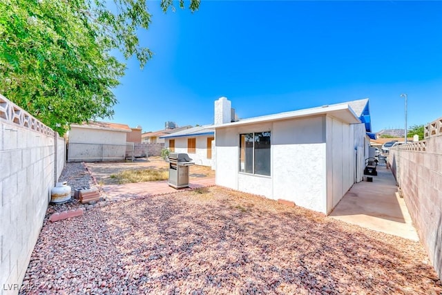 729 Scottsdale St, Henderson, NV 89002 - rear view of property with a fenced backyard, a patio, a chimney, and stucco siding