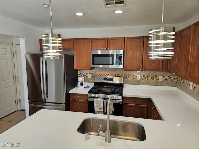 7461 Enviable Ct, Las Vegas, NV 89149 - kitchen with stainless steel appliances, a sink, light countertops, brown cabinetry, and decorative backsplash