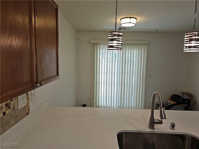 7461 Enviable Ct, Las Vegas, NV 89149 - kitchen with a sink, a chandelier, hanging light fixtures, and light countertops