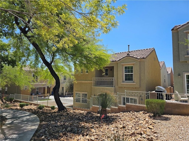 7461 Enviable Ct, Las Vegas, NV 89149 - view of front facade with stucco siding, a tiled roof, fence, and a balcony