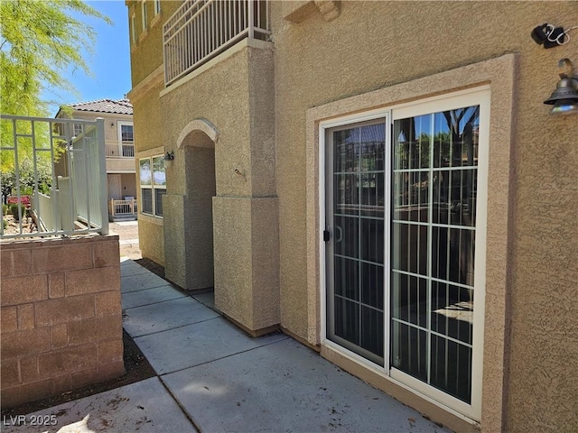 7461 Enviable Ct, Las Vegas, NV 89149 - view of exterior entry with stucco siding and a balcony