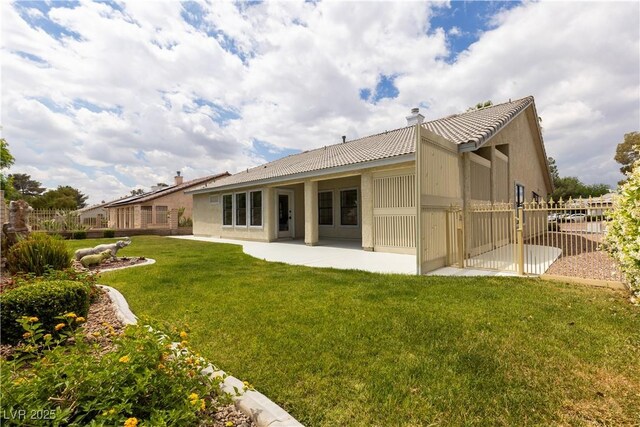 rear view of house featuring a tile roof, a patio, stucco siding, and a chimney