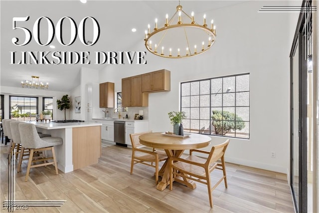 dining room featuring a chandelier, high vaulted ceiling, light wood finished floors, and baseboards