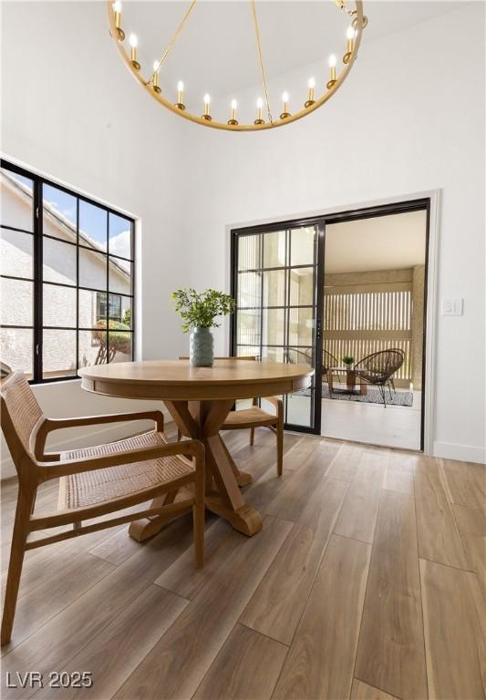 dining space with a chandelier, a high ceiling, and wood finished floors