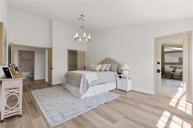 bedroom featuring light wood-type flooring, a chandelier, and baseboards