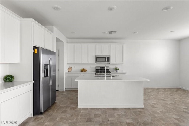 6854 Chargehand Ave, Las Vegas, NV 89156 - kitchen with appliances with stainless steel finishes, light countertops, white cabinets, and an island with sink