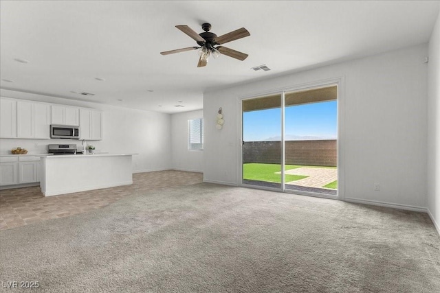 6854 Chargehand Ave, Las Vegas, NV 89156 - unfurnished living room featuring ceiling fan, baseboards, and light carpet