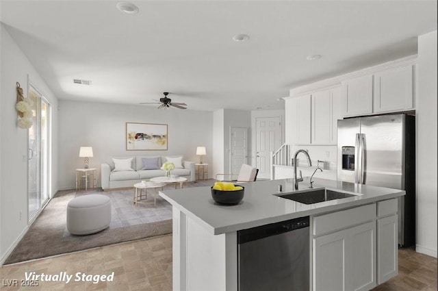 6854 Chargehand Ave, Las Vegas, NV 89156 - kitchen featuring appliances with stainless steel finishes, a sink, white cabinets, ceiling fan, and an island with sink