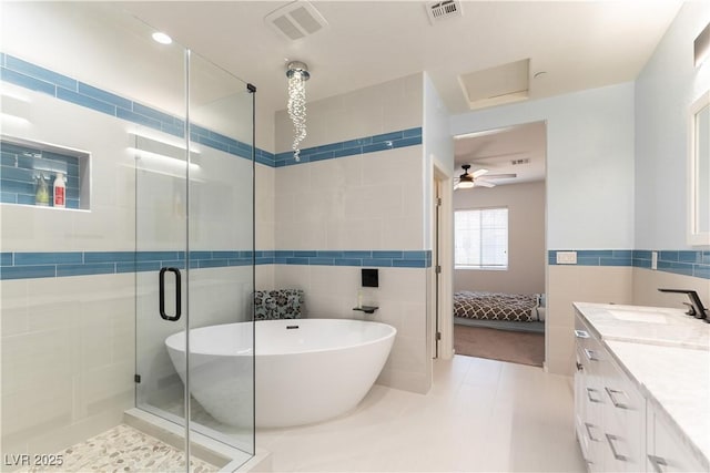 9986 Sand Key St, Las Vegas, NV 89178 - full bathroom featuring tile walls, a stall shower, connected bathroom, a soaking tub, and vanity