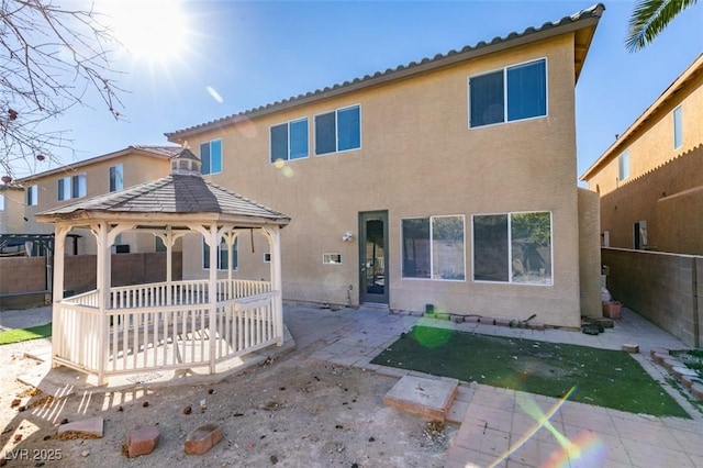 3774 Dusky Flycatcher St, Las Vegas, NV 89122 - back of house featuring a gazebo, a fenced backyard, stucco siding, and a patio