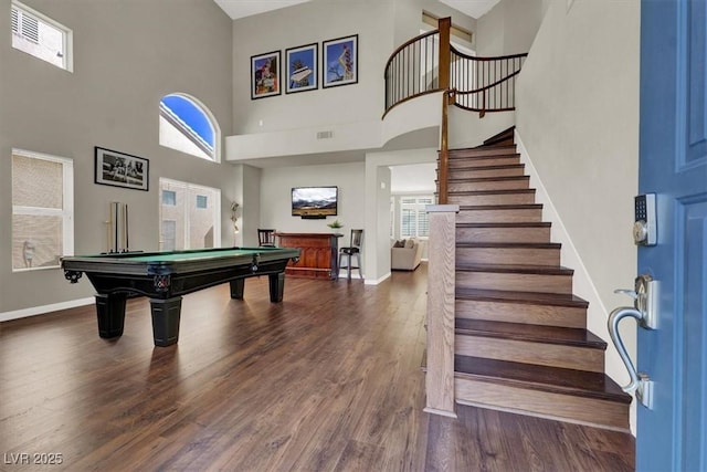 game room featuring a towering ceiling, wood finished floors, baseboards, billiards table, and plenty of natural light