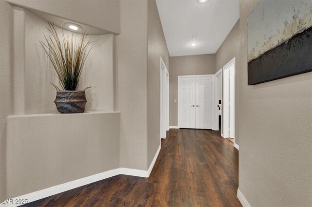 corridor with baseboards and dark wood finished floors