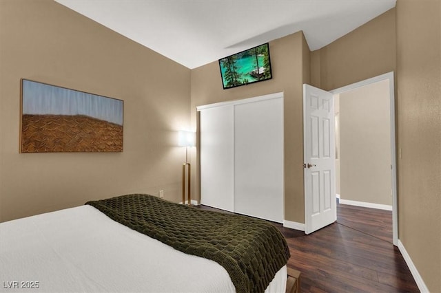 bedroom with wood finished floors, baseboards, and a closet