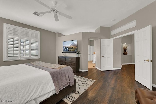 bedroom with wood finished floors, arched walkways, baseboards, and a ceiling fan