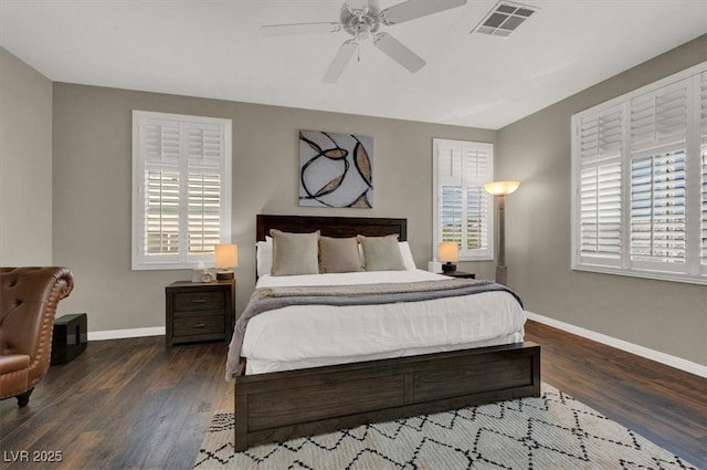 bedroom featuring wood finished floors, multiple windows, and baseboards