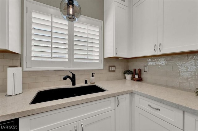 kitchen featuring a sink, white cabinetry, and decorative backsplash
