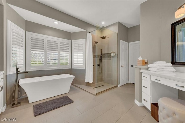 full bath featuring a shower stall, a freestanding tub, vanity, tile patterned flooring, and recessed lighting