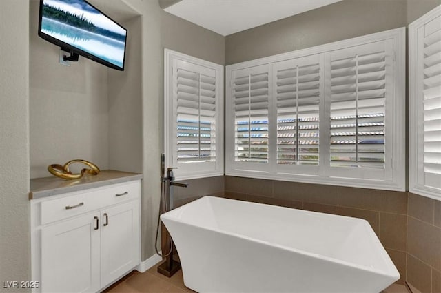 bathroom with a soaking tub and tile patterned floors