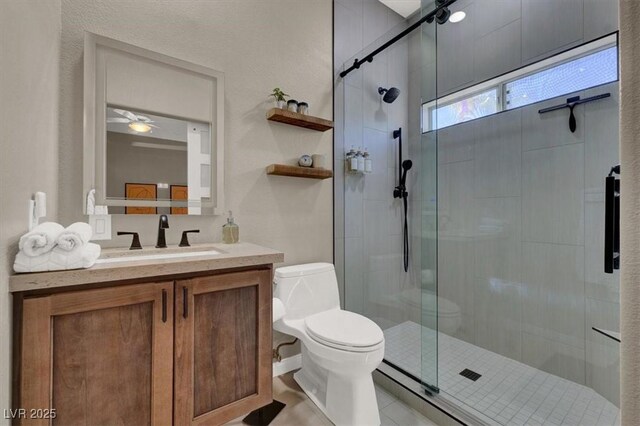 bathroom with a stall shower, toilet, vanity, and tile patterned floors