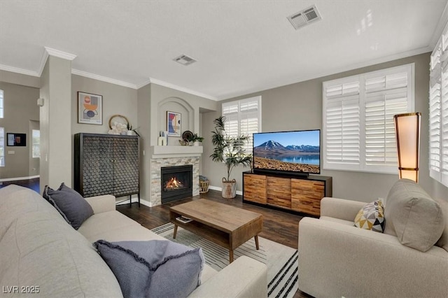 living room with wood finished floors, baseboards, healthy amount of natural light, and ornamental molding