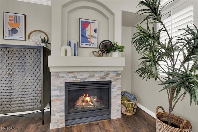 detailed view of wood finished floors, baseboards, and a fireplace