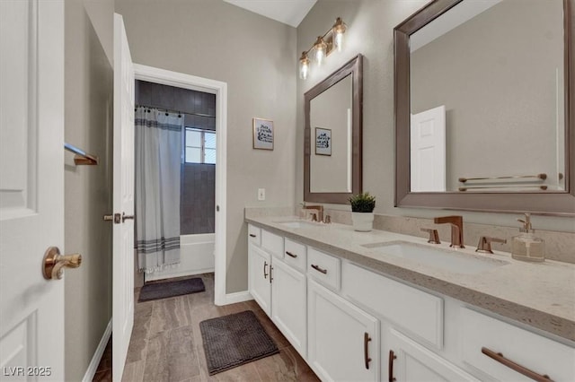 bathroom featuring double vanity, baseboards, and shower / bath combo with shower curtain